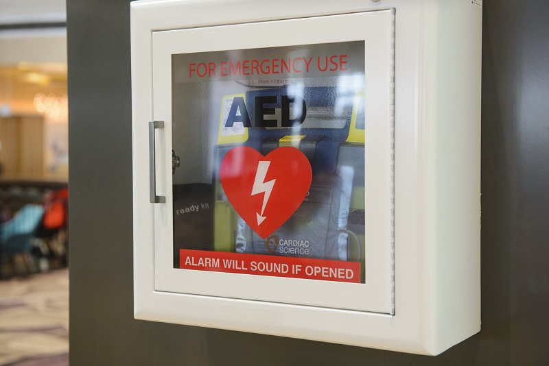 An AED, or automated external defibrillator, in a case on a wall.