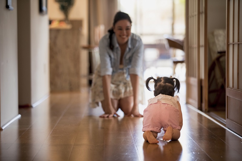 Baby crawling towards mother, meeting developmental milestones