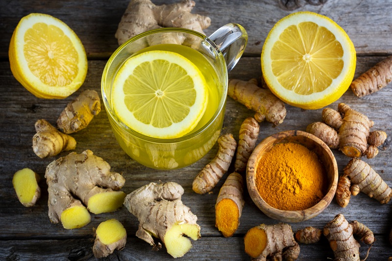 Ginger, lemons and tea on a tabletop.