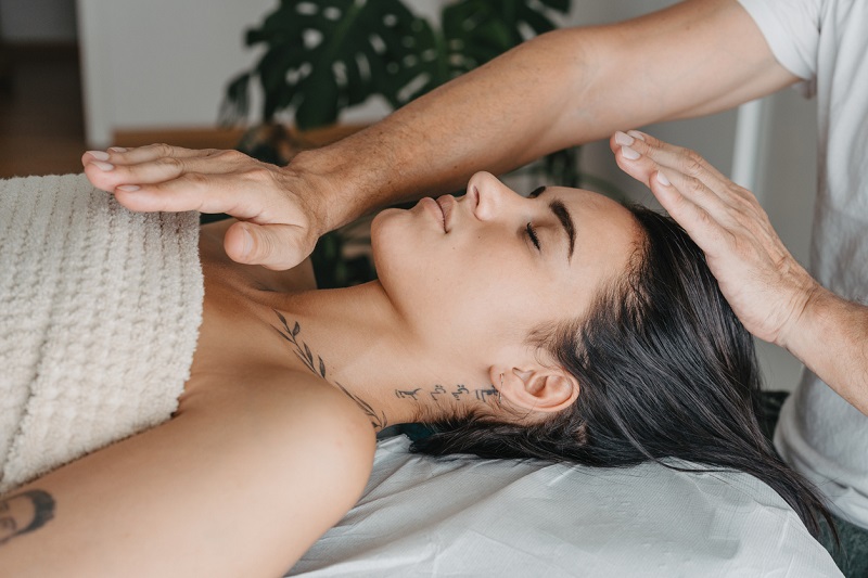 Side profile of a woman while receiving energy in a Reiki therapy.