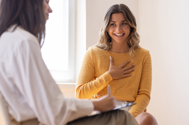 Primary care provider listening to a brunette patient talking.