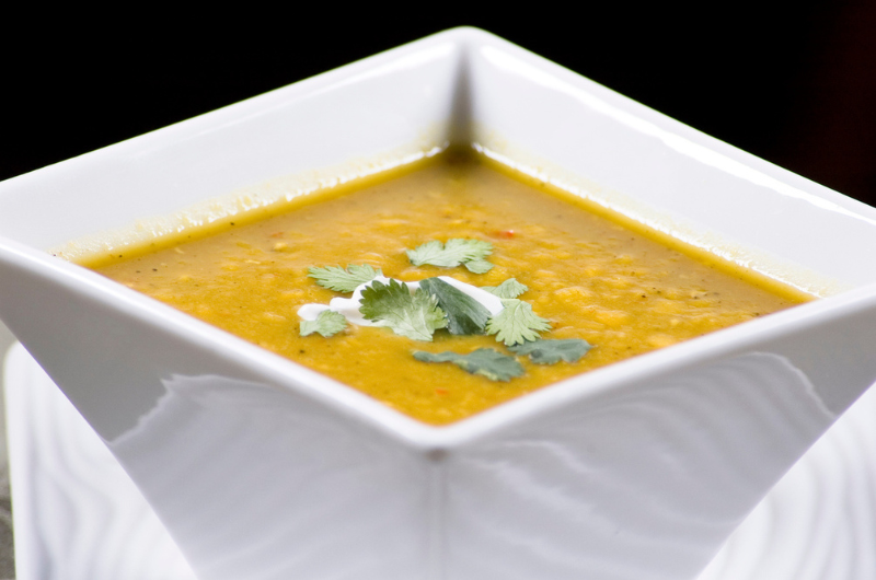Split pea soup in a square bowl.
