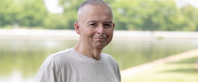 John Toussas standing by a lake